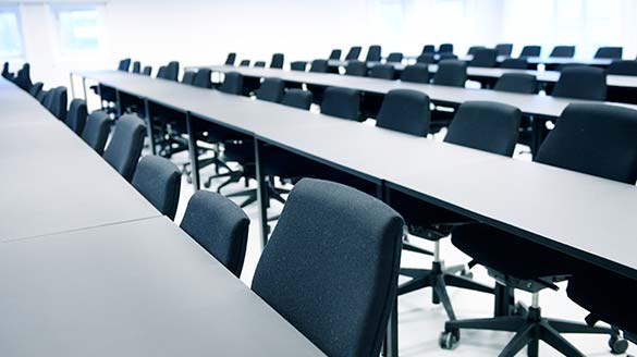 Graduate House indenfor i et klasseværelse med borde og stole